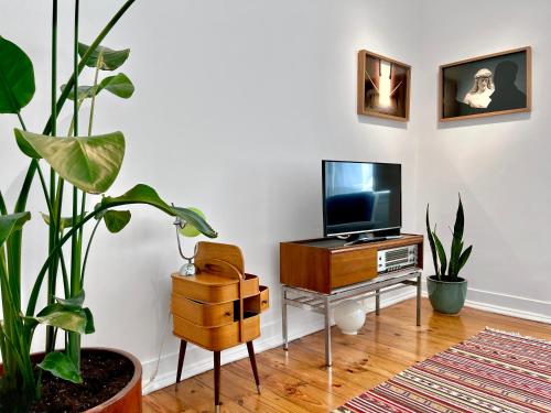 un soggiorno con TV su un tavolo con piante di New Art Apartment a Lisbona