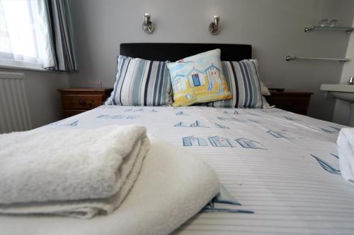 a bed with a white comforter and pillows at The Pebbles - Adults Only in Weymouth
