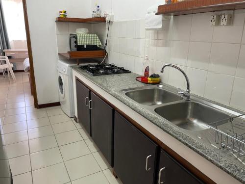 cocina con fregadero y fogones en Private Apartment Wakin Residence, City Centre, Port Louis en Port Louis