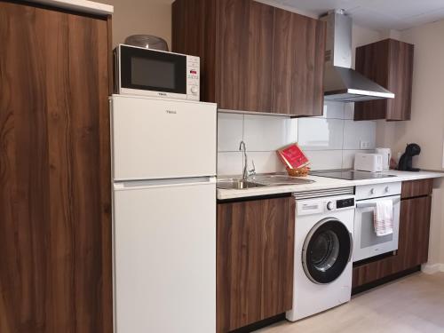 a kitchen with a white refrigerator and a microwave at La Casona del Eboni in Alcalá de Henares
