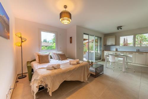 a bedroom with a large bed and a kitchen at Aux balcons annéciens- Entre Lac et centre ville, LLA Selections by Location lac Annecy in Sévrier