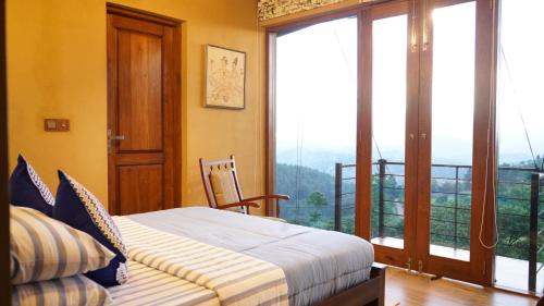 KamburadeniyaにあるKandy Hindagala Retreat - Boutique Villa in Kandy Hills Sri Lankaのベッドルーム1室(ベッド1台付)、景色を望むバルコニーが備わります。