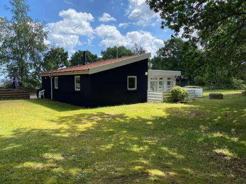 a black and white house with a yard at 7 person holiday home in rsted in Kare