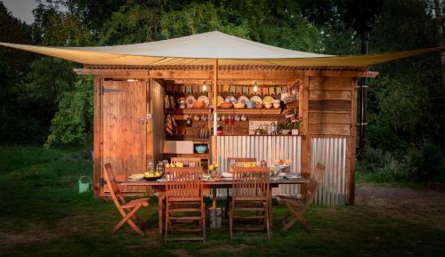 a gazebo with a table and chairs in a yard at 8-Bed Lotus Belle Mahal Tent in The Wye Valley in Ross on Wye