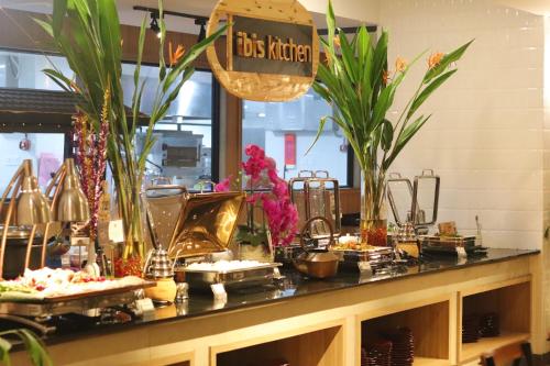 a buffet of food on a counter with plants at ibis Pontianak City Center in Pontianak