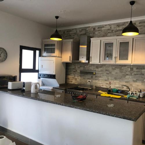a kitchen with white cabinets and a counter top at Lovely penthouse 4- bedroom directly on the lagoon in El Alamein