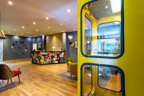 a yellow bus in a room with a table and chairs at tinyTwice Hotel Bonn in Bonn