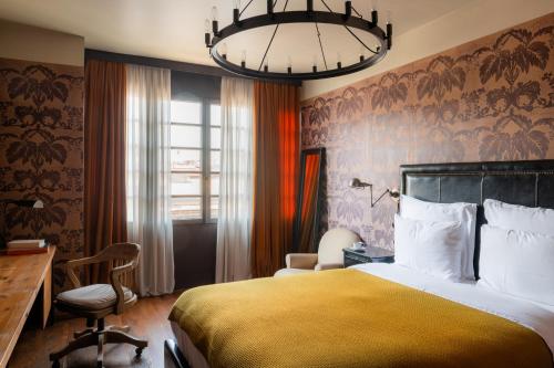فندق رومز تبليسي في تبليسي: غرفه فندقيه بسرير ومكتب ونافذه