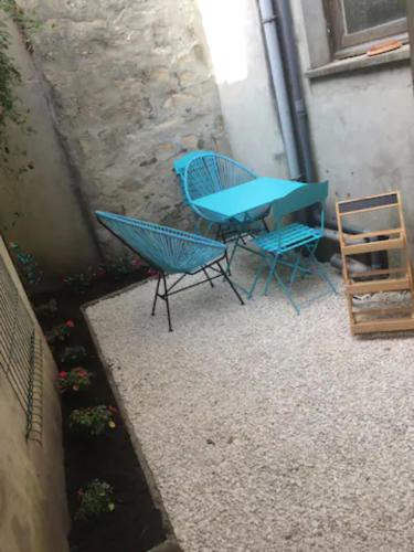 ein blauer Tisch und Stühle neben einem Gebäude in der Unterkunft Appartement Hypercentre de Milly in Milly-la-Forêt