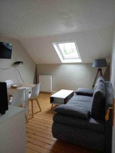 a living room with a couch and a window at Appartement Hypercentre de Milly in Milly-la-Forêt