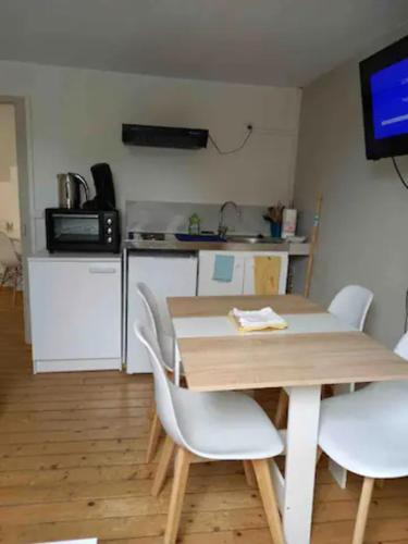 eine Küche mit einem Holztisch und weißen Stühlen in der Unterkunft Appartement Hypercentre de Milly in Milly-la-Forêt