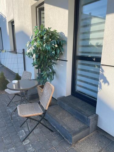a patio with two chairs and a table next to a door at Apartament Platinum Park in Stargard