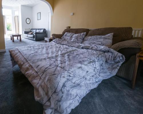 a bed in a bedroom with a blanket on it at NEWTON HEATH APARTMENT -750mtrs to beach - Spacious ground floor - Sleeps 6 in Porthcawl