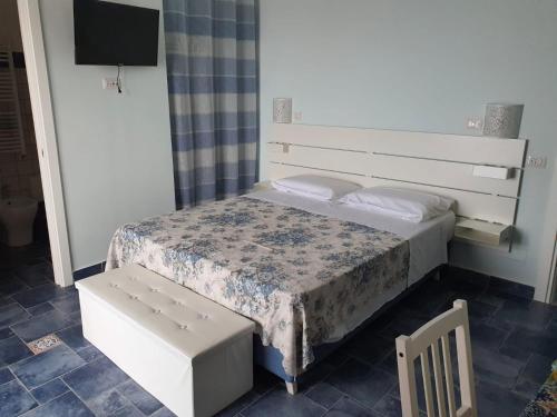 um pequeno quarto com uma cama e uma televisão em La Casa di Nunzia B&B em Positano