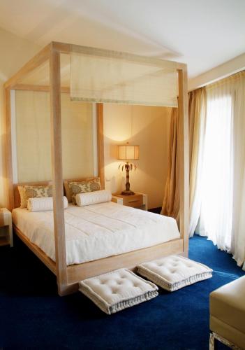 a bedroom with a canopy bed with two pillows at Hotel Moliceiro in Aveiro