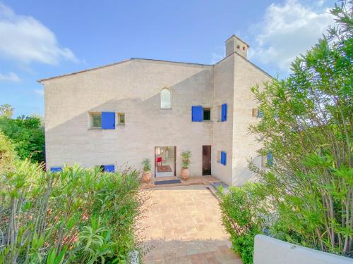 een stenen huis met blauwe ramen en een deur bij Villa St Maxime in Saint-Paul-de-Vence