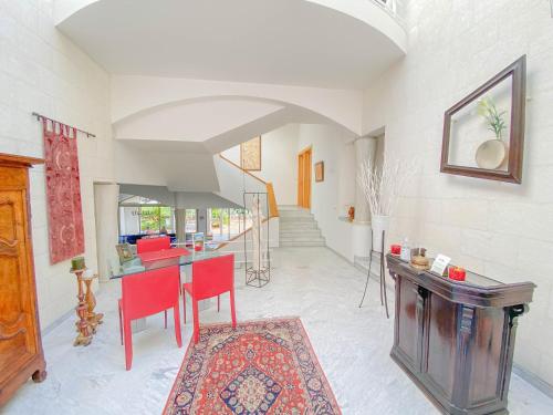 a living room with red chairs and a table at Villa St Maxime in Saint Paul de Vence