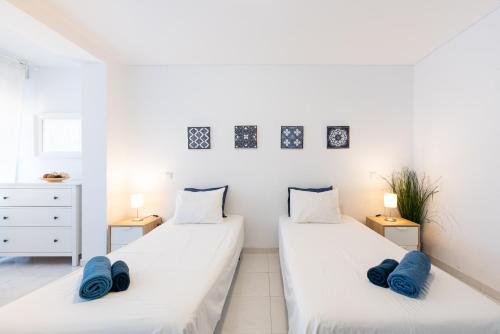 トレモリノスにあるEurosol Carihuelaの白い部屋のベッド2台 青い枕付