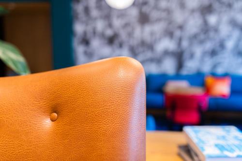 an orange chair sitting at a table with a keyboard at Vie Via - Your Hotel in Leeuwarden