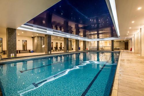 a large swimming pool in a building at Holiday Inn London Kensington High St., an IHG Hotel in London