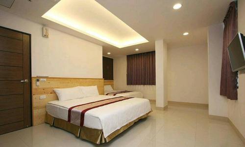 a bedroom with two beds and a television in it at Ziteng Hua Homestay in Hualien City