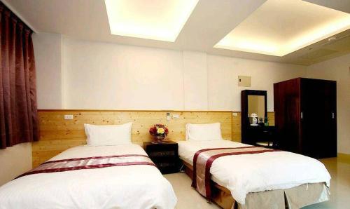 花蓮市的住宿－紫藤花民宿，一间客房内配有两张床的房间