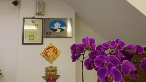 a bunch of purple flowers in a vase next to a wall at Ziteng Hua Homestay in Hualien City