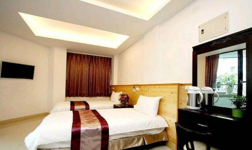 a hotel room with two beds and a piano at Ziteng Hua Homestay in Hualien City