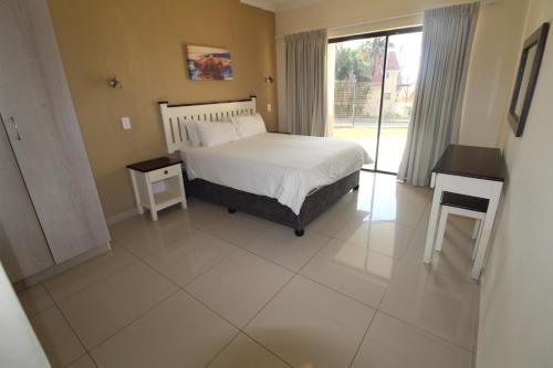 - une chambre avec un lit blanc et une fenêtre dans l'établissement Saints View Resort Unit 4, à Uvongo Beach