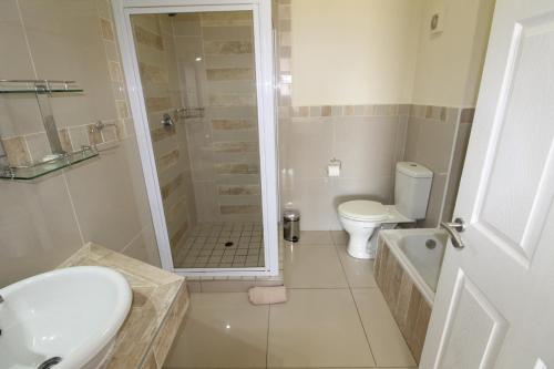a bathroom with a shower and a toilet and a sink at Saints View Resort Unit 4 in Uvongo Beach