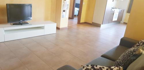 een woonkamer met een televisie en een bank bij APPARTAMENTO TORRE in Cormano