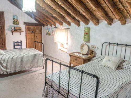 a bedroom with two beds and a table with a mirror at Casa Rural Huerta la Lapa in Cañete la Real