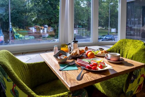 a wooden table with food on top of it in front of a window at tinyTwice Hotel Bonn in Bonn