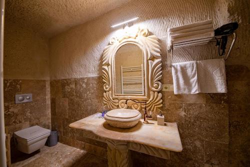 a bathroom with a toilet and a large mirror at FARMER CAVE HOUSE in Urgup