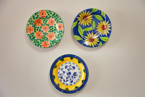 three plates on a table with flowers on them at 21 ON BAKOOND in Yzerfontein