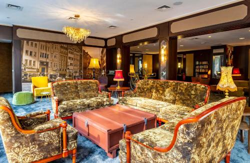 a living room with couches and chairs and a table at tinyTwice Hotel Bonn in Bonn