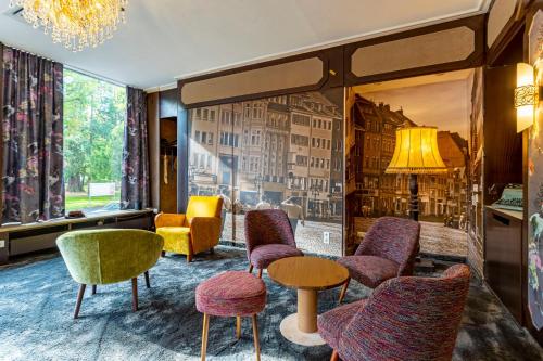 a lobby with colorful chairs and tables and a window at tinyTwice Hotel Bonn in Bonn