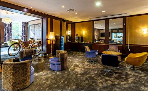a lobby with chairs and a bar with a bicycle at tinyTwice Hotel Bonn in Bonn