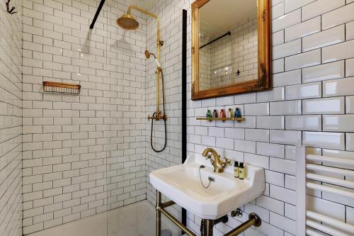 uma casa de banho branca com um lavatório e um espelho em Le studio du sorcier ! em Paris