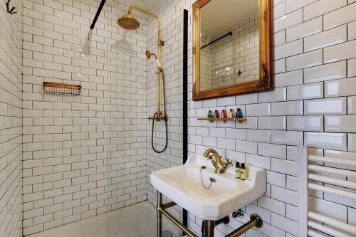 une salle de bain blanche avec un lavabo et un miroir dans l'établissement The wizard's studio!, à Paris