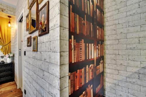 uma parede de tijolos com livros emoldurados em Le studio du sorcier ! em Paris