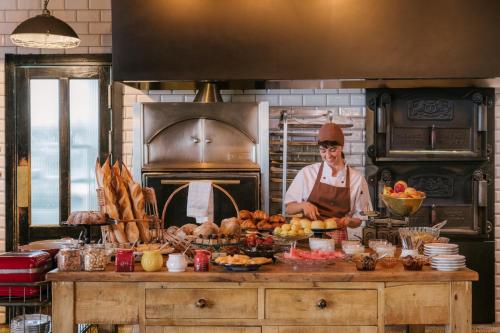 a chef standing in a kitchen with a table of food at Rooms Hotel Tbilisi in Tbilisi City