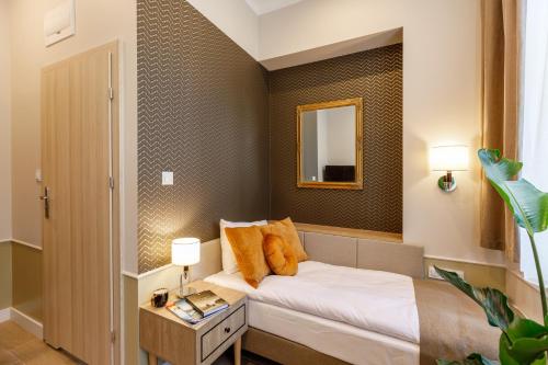 una piccola camera con letto e specchio di AR Apartamenty a Poznań
