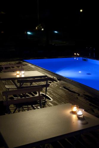 a swimming pool at night with a table and lights at Locanda Dell' Orso Bevitore in Verduno