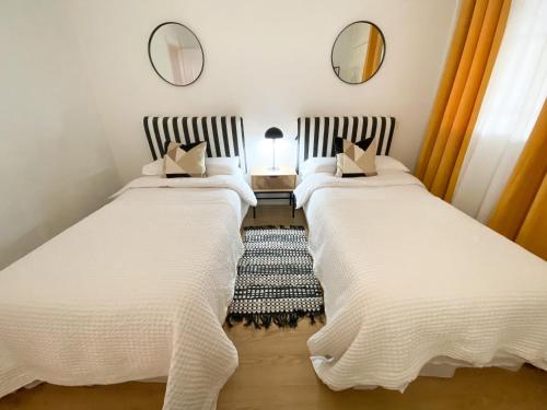 duas camas num quarto com dois espelhos em Apartamento Brisas em Sevilha