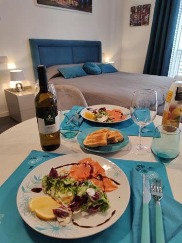 羅馬的住宿－The Rabbit Hole，一张桌子,上面放着两盘食物和一瓶葡萄酒