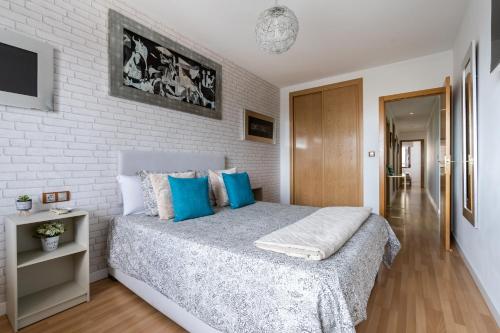 - une chambre avec un grand lit et des oreillers bleus dans l'établissement Apartamento Levante en Chinchilla con vistas, à Chinchilla de Monte-Aragón