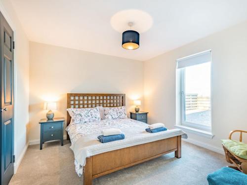 a bedroom with a bed and a large window at West Burnside Beach Cottage in Tayinloan
