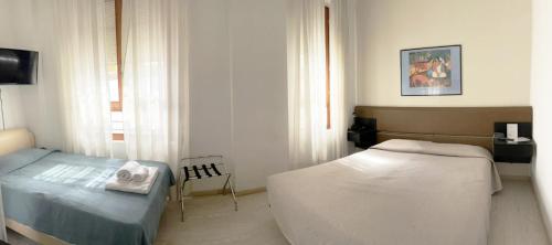 a bedroom with a bed and a chair in it at Hotel Molise 2 in Milan
