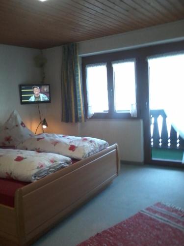 a bedroom with a bed and a tv on the wall at Urlaub auf dem Hänslehof in Elzach